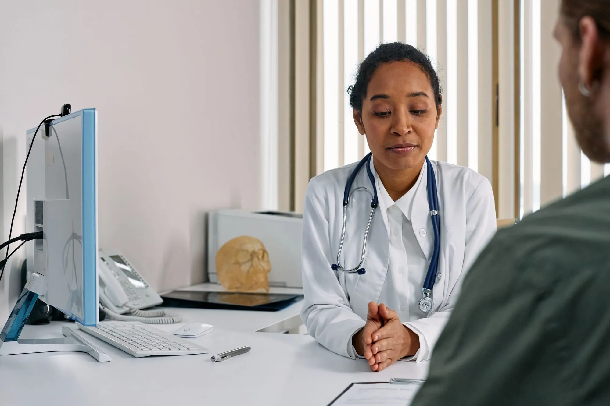 Médica escuta um paciente no consultório